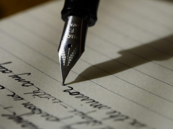 1. A fountain pen glides across a piece of paper, leaving a trail of ink as it writes.